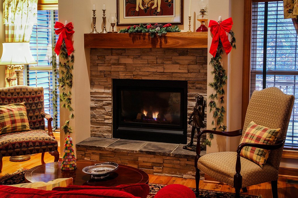 stone fireplace in living room with holiday decorations
