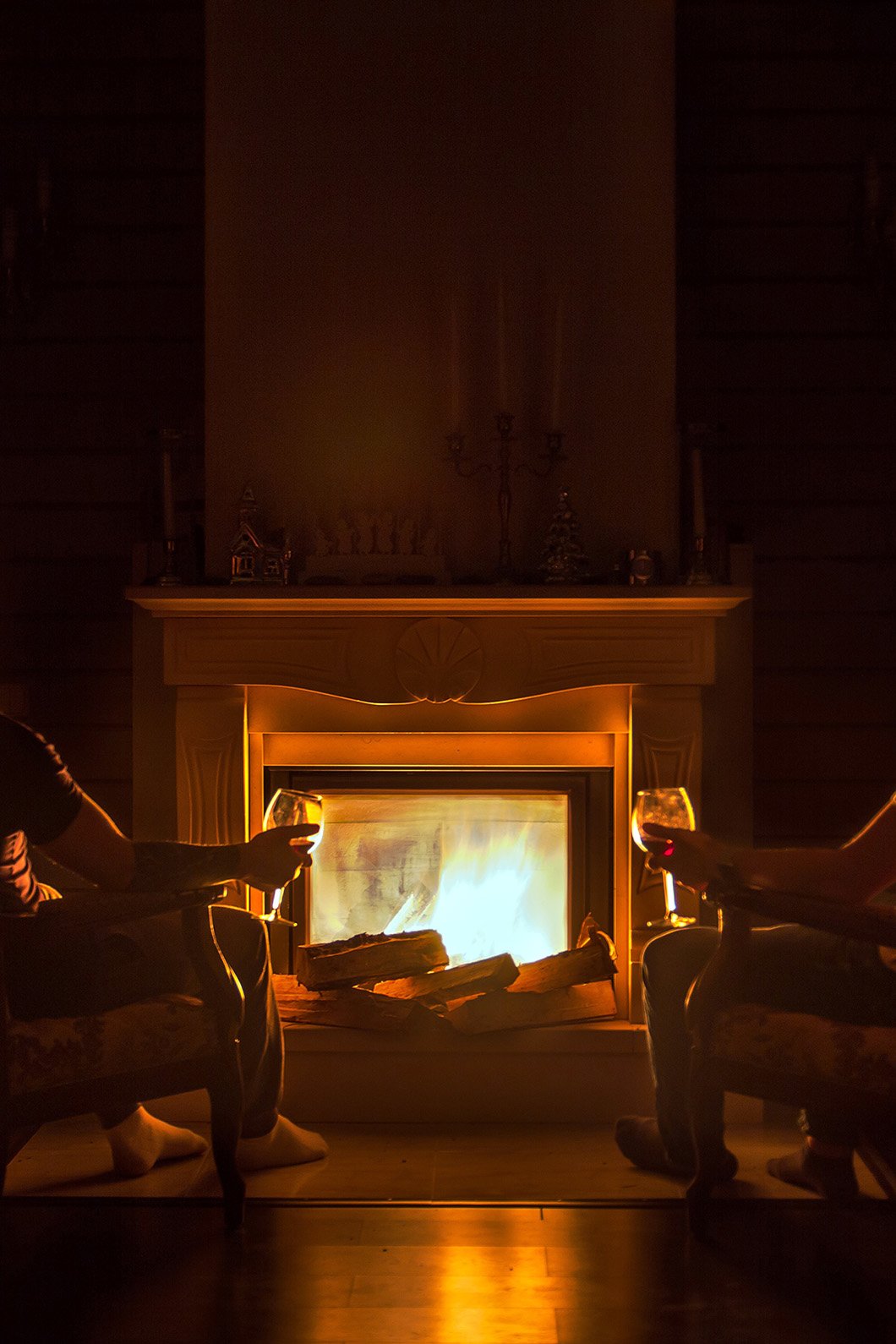 two people sitting in front of a fireplace
