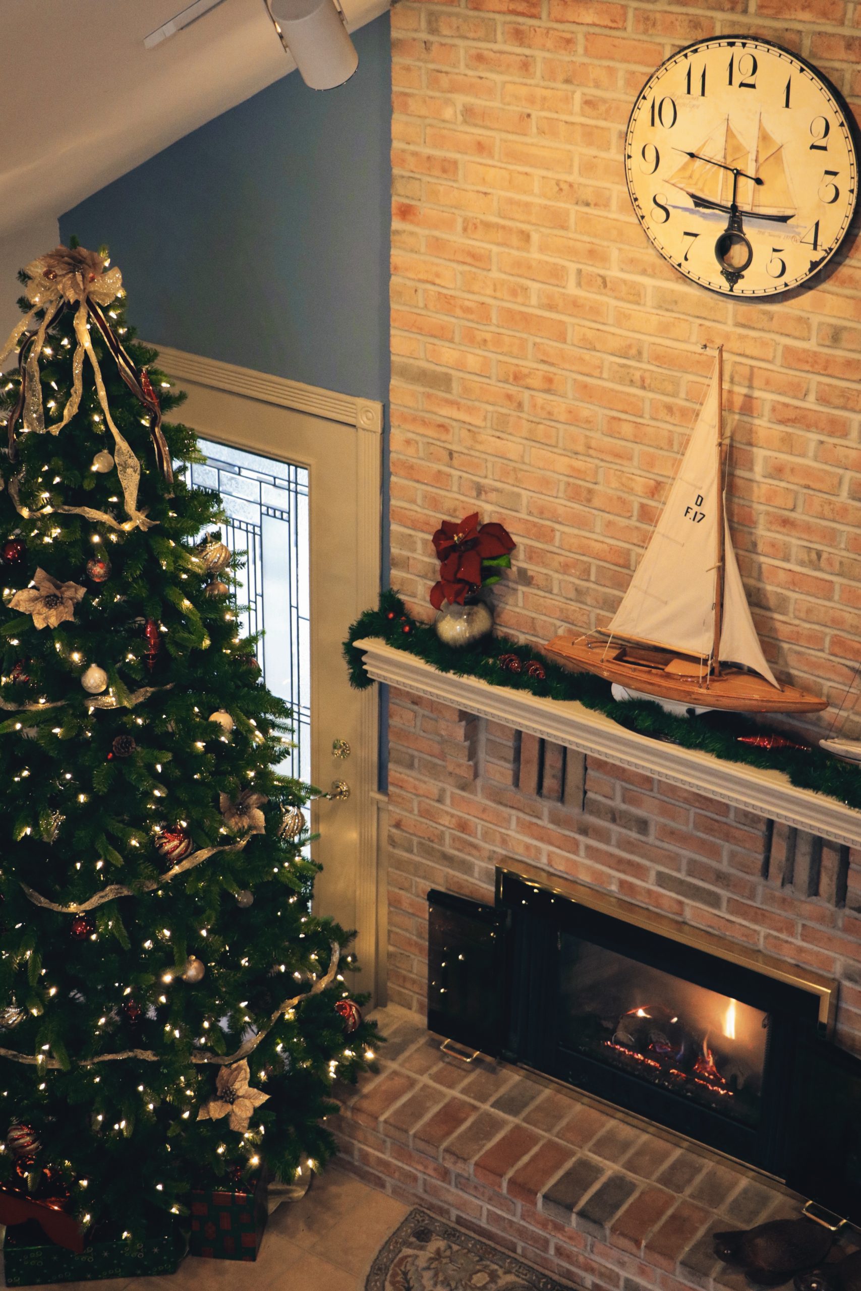 A fire place sitting in a living room with a christmas tree